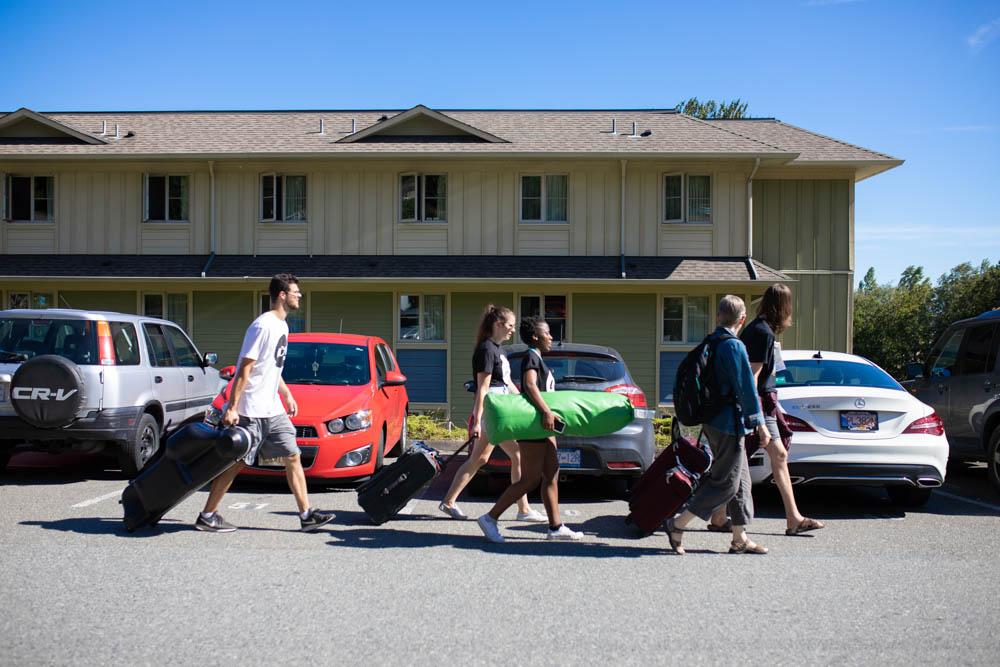 Excited students with suitcases moving into Residence